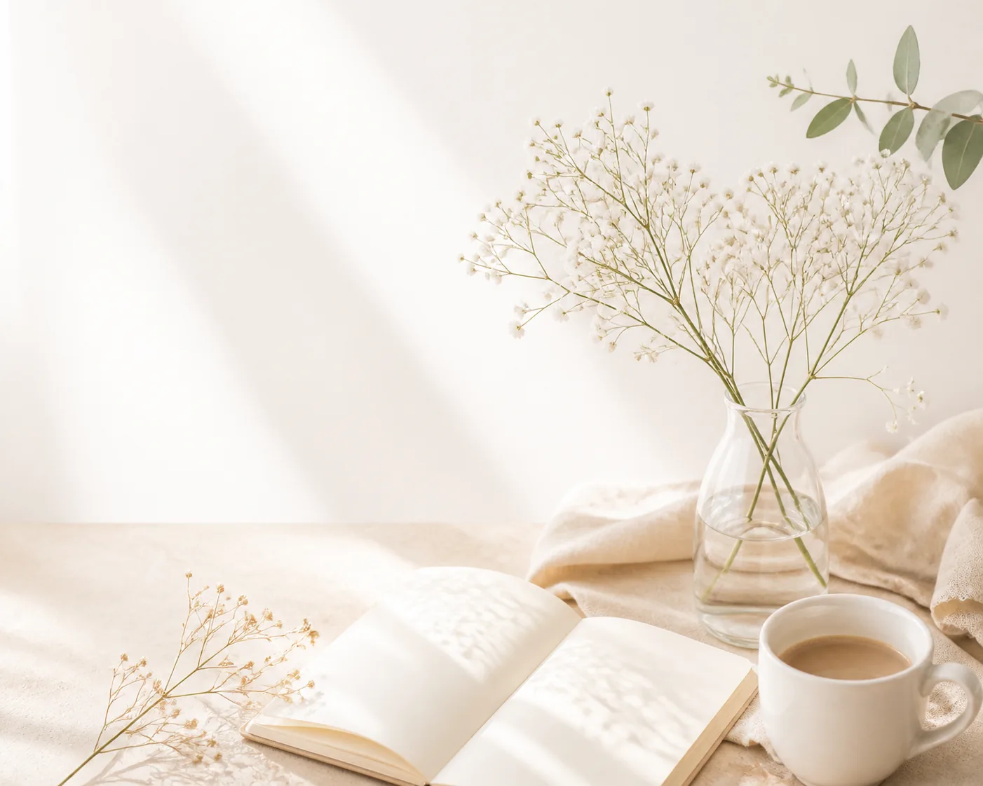白い花とノートとコーヒーの淡い制作風景